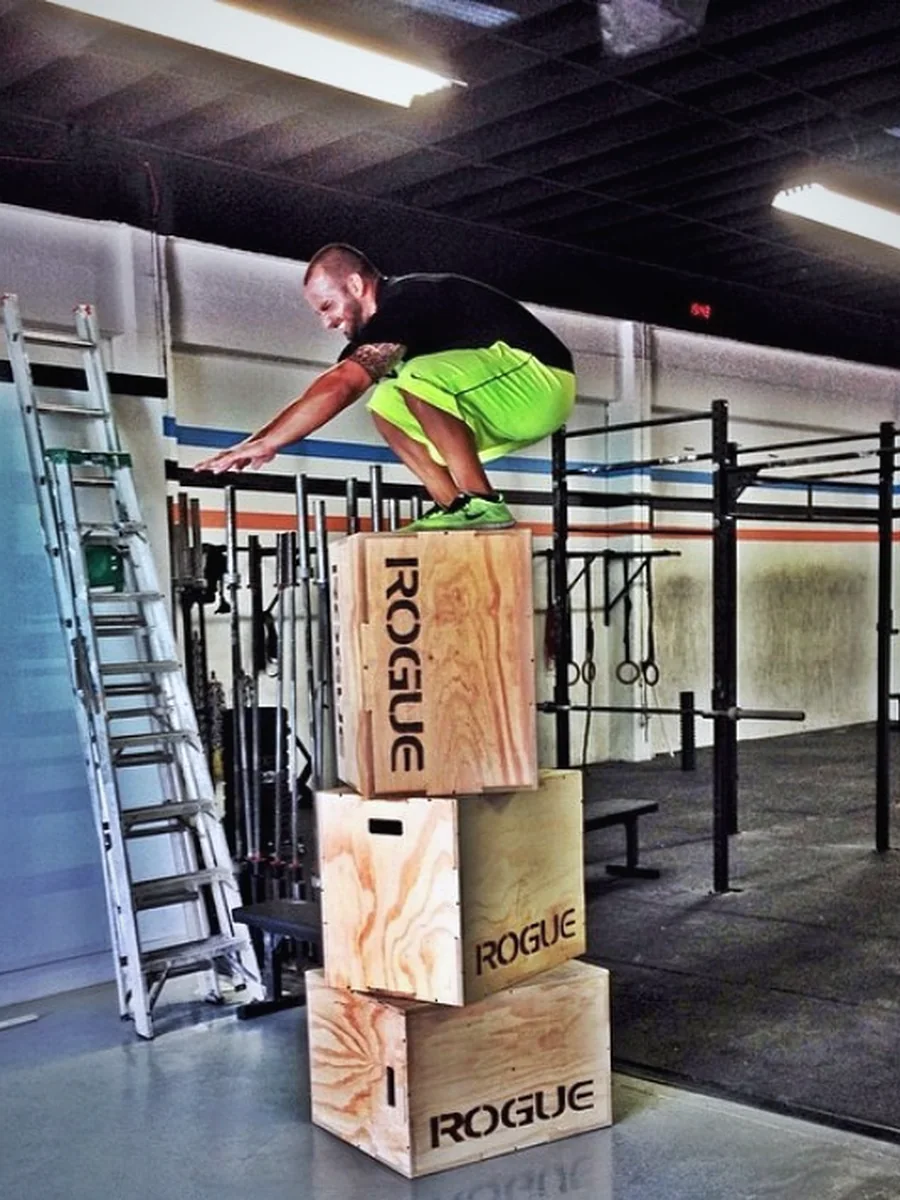 An athlete at the top of a stacked box jump — grit, made in Little River